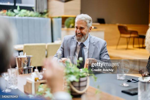 lächelnde geschäftsleute genießen die mittagspause im restaurant - business dinner meeting stock-fotos und bilder