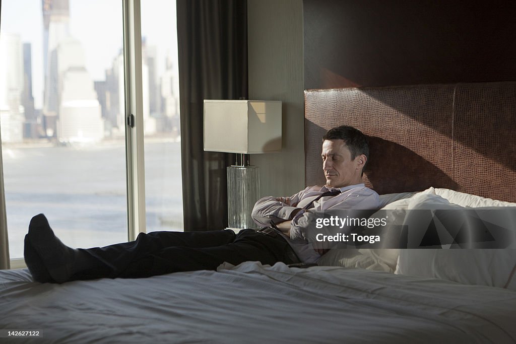 Businessman taking a nap on bed