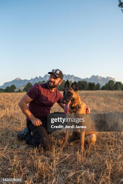 happy dog trainer with his dog, resting from his workday - sports training bildbanksfoton och bilder