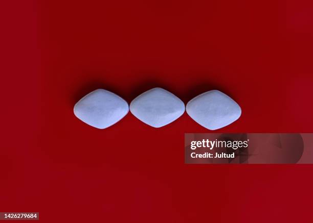 colorful pills isolated on red background overhead shot - erectie stockfoto's en -beelden