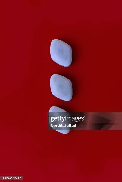 colorful pills isolated on red background overhead shot - erectie stockfoto's en -beelden