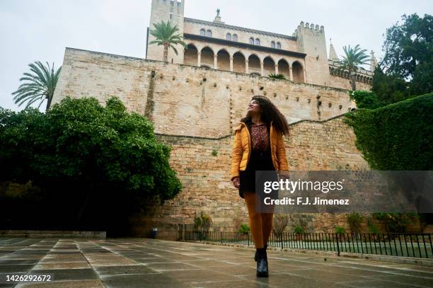 woman walking around the cathedral of palma de mallorca - palma maiorca stock-fotos und bilder