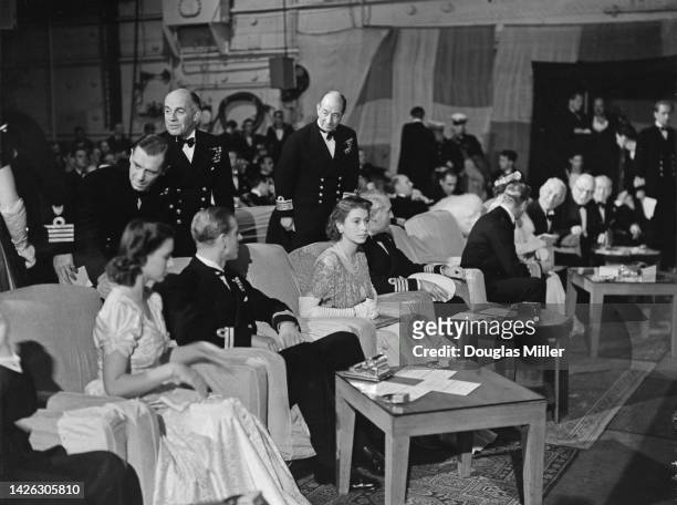 Princess Elizabeth and her fiancee, Prince Philip in their seats for a concert party on board the Royal Navy aircraft carrier HMS Illustrious , which...