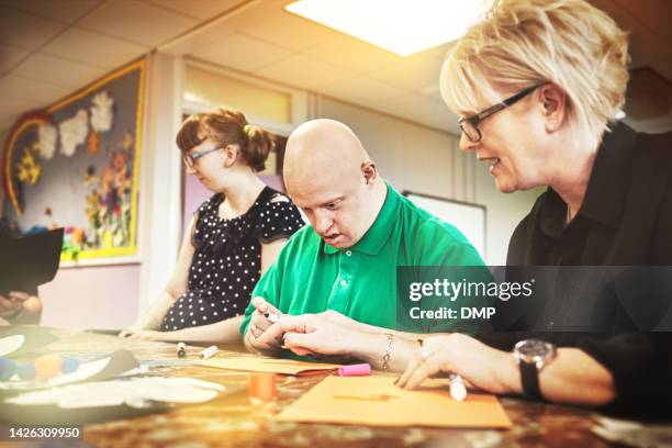 down syndrome, disability care and healthcare woman worker with disabled people teaching art. creative activity at a wellness, medical and caring home or clinic with a senior female and man learning - adult with disability stock pictures, royalty-free photos & images