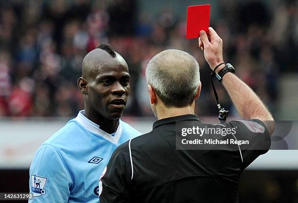 Referee Martin Atkinson shows Mario Balotelli of Man City a red card during the Barclays Premier League match between Arsenal and Manchester City at...