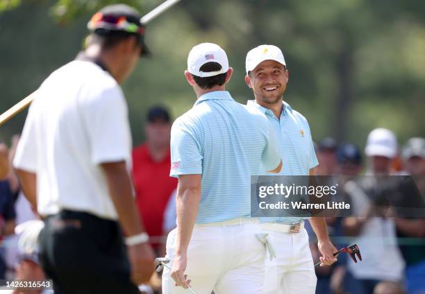 Xander Schauffele of the United States Team congratulates teammate Patrick Cantlay on his putt on the sixth green during the Thursday foursome...