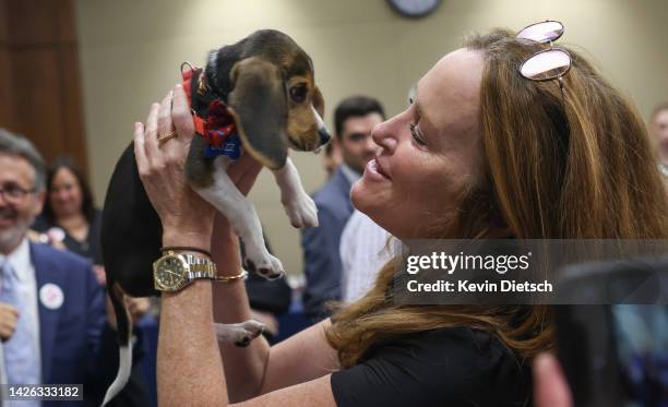 Woman holds a beagle puppy that was saved from a medical research facility during an event to highlight the Companion Animal Release from Experiments...