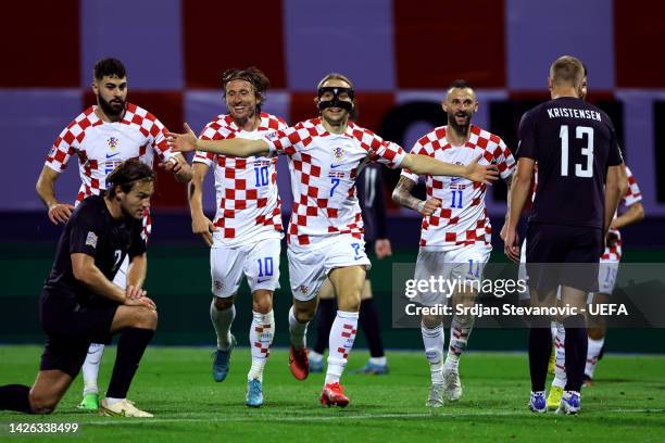 Lovro Majer of Croatia celebrates with teammates Luka Modric and Marcelo Brozovic after scoring their side's second goal during the UEFA Nations...