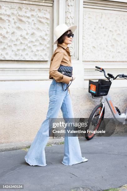 Guest is seen wearing denim pants, fedora white hat and camel shirt outside Max Mara show during the Milan Fashion Week - Womenswear Spring/Summer...