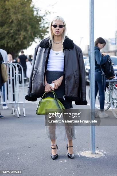 Vanessa Hong is seen wearing an aviator jacket, Prada white tank top a, green Prada bag and skirt outside Prada show during the Milan Fashion Week -...