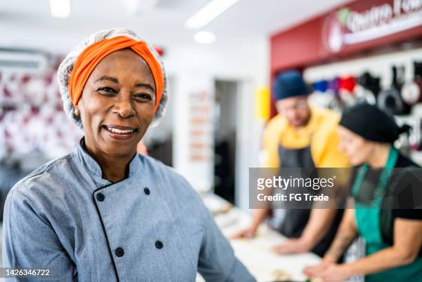 portrait of a senior woman at the kitchen - hair net stock pictures, royalty-free photos & images