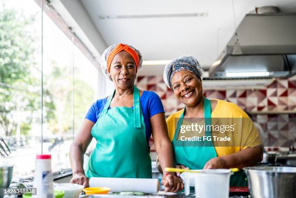 portrait of happy senior students during cooking class or working in a restaurant - hair net stock pictures, royalty-free photos & images