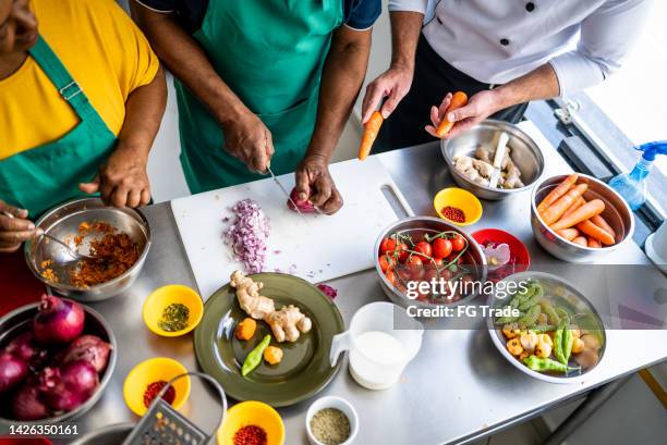 mains coupant l’oignon dans la cuisine - cours de cuisine photos et images de collection