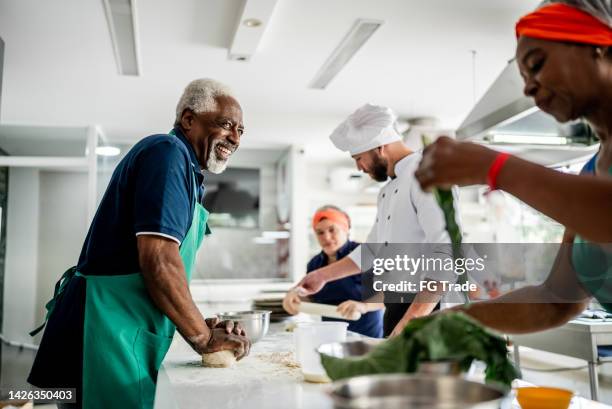 senior man making pasta in a cooking class - nutrition coach stock pictures, royalty-free photos & images