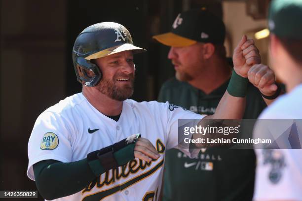 Stephen Vogt of the Oakland Athletics celebrates in the dugout after scoring on a double by Shea Langeliers in the bottom of the third inning against...