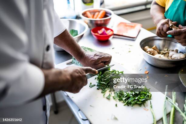 human hands chopping vegetables - black chef stock pictures, royalty-free photos & images