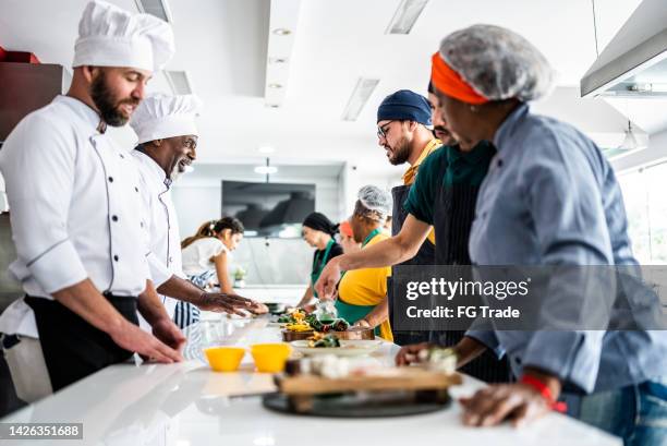 chef analizando la comida preparada por los estudiantes durante la clase de cocina - dining presentation food fotografías e imágenes de stock