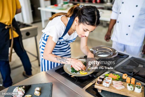 young woman preparing sushis at the kitchen - making sushi stock pictures, royalty-free photos & images