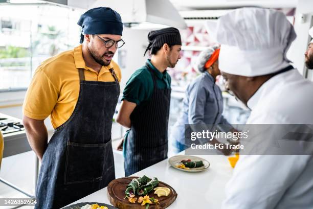 chef analyzing food prepared by students during cooking class - cooking contest stock pictures, royalty-free photos & images