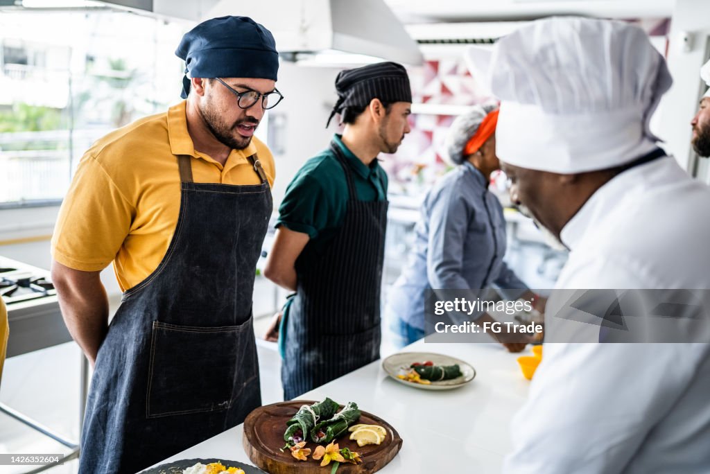 Chef analyzing food prepared by students during cooking class