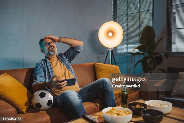 watching soccer game at home - glee tv program stockfoto's en -beelden