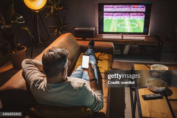 watching soccer game at home - tv program stockfoto's en -beelden