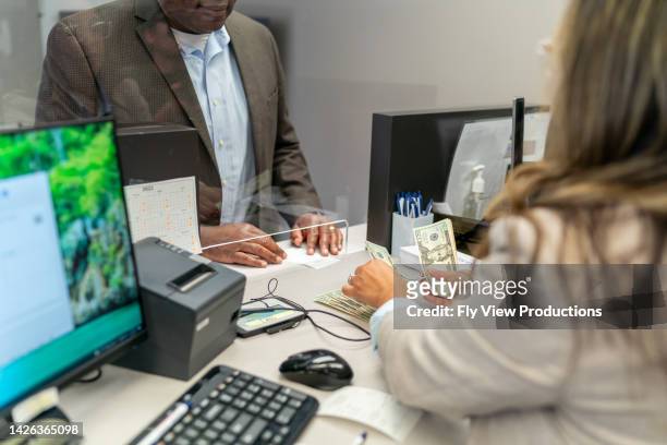 bank teller counting money for customer - bank teller stock pictures, royalty-free photos & images