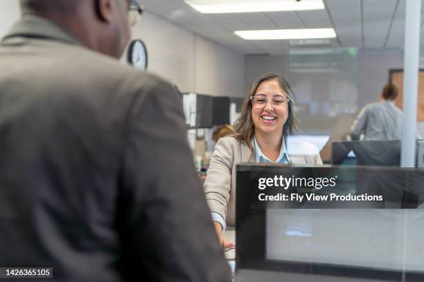 cheerful customer service representative greeting customer - bank teller and customer stock pictures, royalty-free photos & images