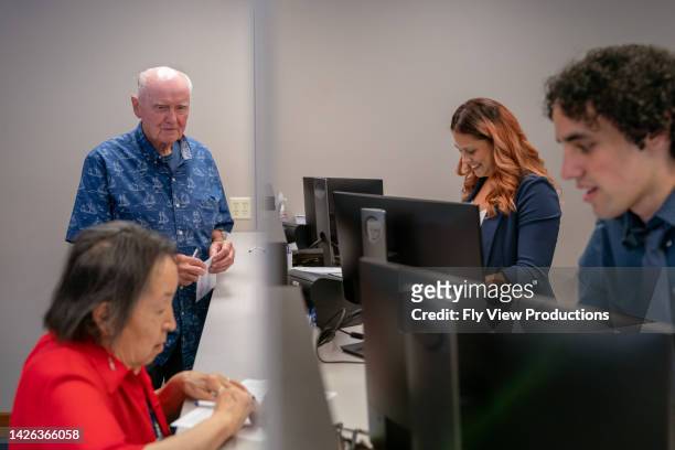 customer service representatives working at reception desk - bank office clerks stock pictures, royalty-free photos & images