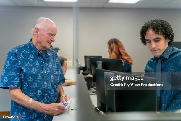 senior man at reception desk - bank counters stock pictures, royalty-free photos & images