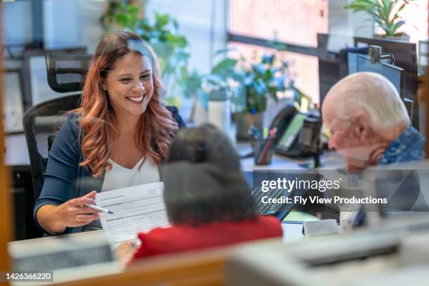 female businesswoman in meeting with senior couple - vulnerability stock pictures, royalty-free photos & images