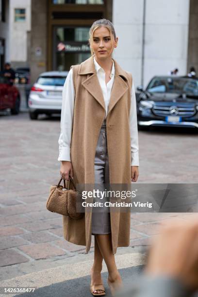 Valentina Ferragni wears beige sleeveless coat, teddy bag, white button shirt outside Max Mara during the Milan Fashion Week - Womenswear...