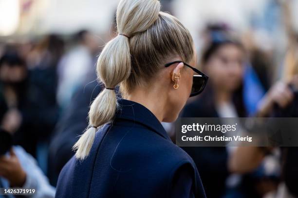 Victoria Magrath with pigtail wears sleeveless double breasted navy jacket, black mid knee high boots, bag, sunglasses outside Max Mara during the...