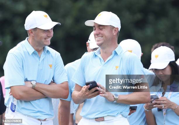 Jordan Spieth of the United States Team and Justin Thomas of the United States Team laugh as they talk and watch play on the 18th green during the...