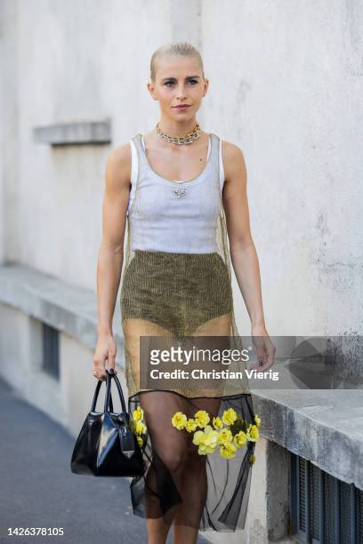 Caroline Daur wears see trough dress, black shorts, white shirt with logo, black bag, heels outside Prada during the Milan Fashion Week - Womenswear...