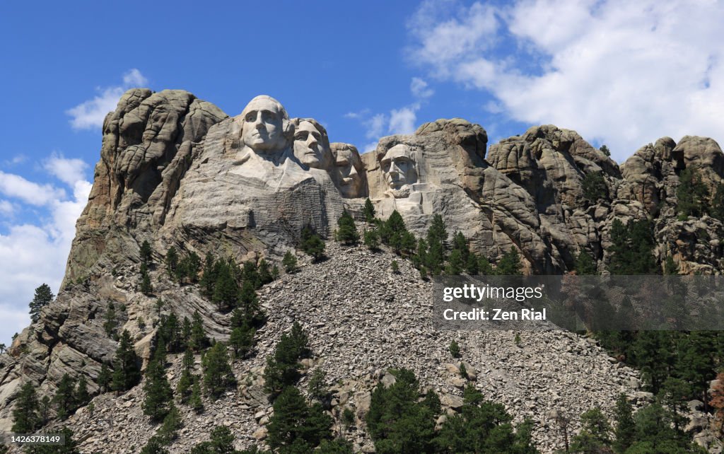 Mount Rushmore with the sculpted faces of four US Presidents and below are pieces of rocks from sculpting