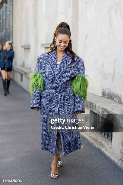 Lena Mahfouf wears grey fishbone oversized coat, heels outside Prada during the Milan Fashion Week - Womenswear Spring/Summer 2023 on September 22,...