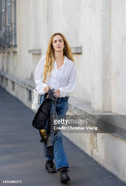 Guest wears white blouse denim jeans outside Prada during the Milan Fashion Week - Womenswear Spring/Summer 2023 on September 22, 2022 in Milan,...