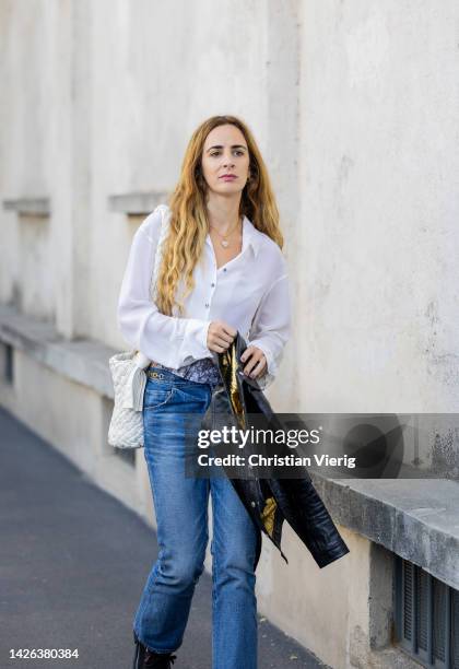 Guest wears white blouse denim jeans outside Prada during the Milan Fashion Week - Womenswear Spring/Summer 2023 on September 22, 2022 in Milan,...