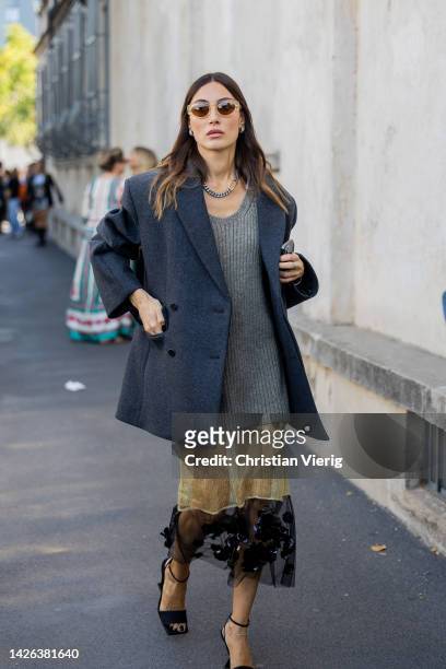Giorgia Tordini wears grey blazer, knit, two tone beige black see trough skirt, sunglasses, necklace outside Prada during the Milan Fashion Week -...