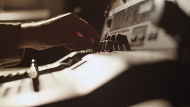 Producer turning knobs on soundboard