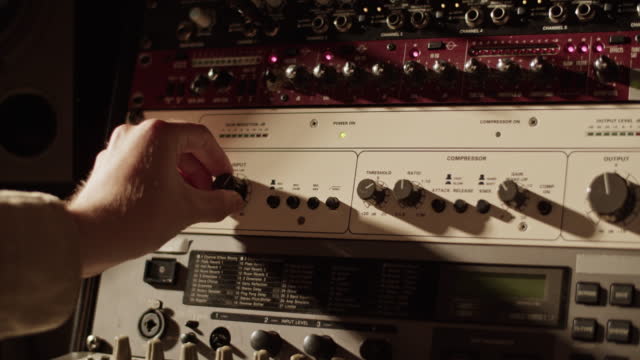 Man turning control knob on amplifier