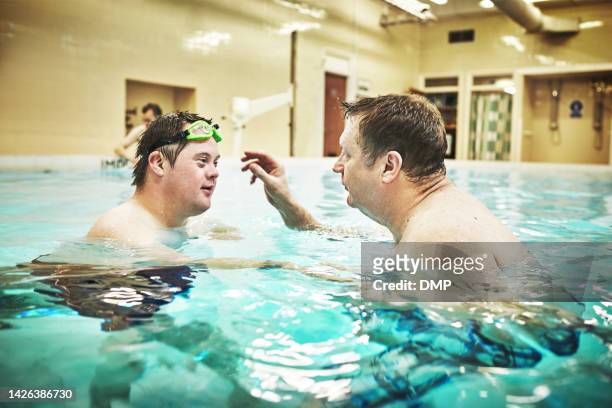 pool, disability and down syndrome man in swimming class for exercise, mental and physical development in water. fitness, workout and disabled person learning to swim and float at special home - autistic adult imagens e fotografias de stock