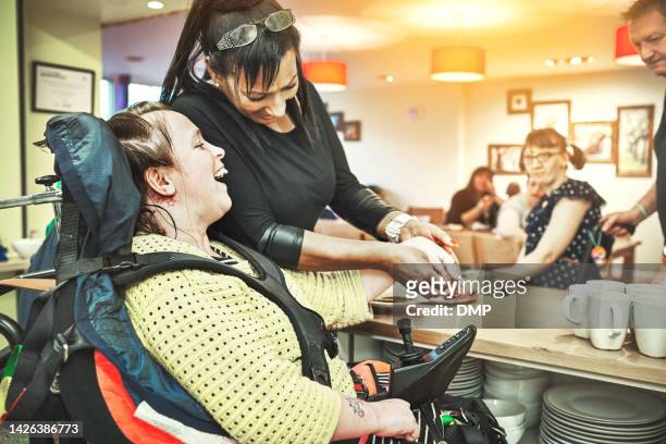 wheelchair down syndrome disability girl patient in clinic or hospital with nurse or professional healthcare worker. nursing and medical caregiver helping happy, friendly and young disabled person - community service stock pictures, royalty-free photos & images