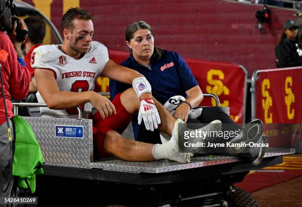 Quarterback Jake Haener of the Fresno State Bulldogs is helped off the field after an injury in the second half against the USC Trojans at United...