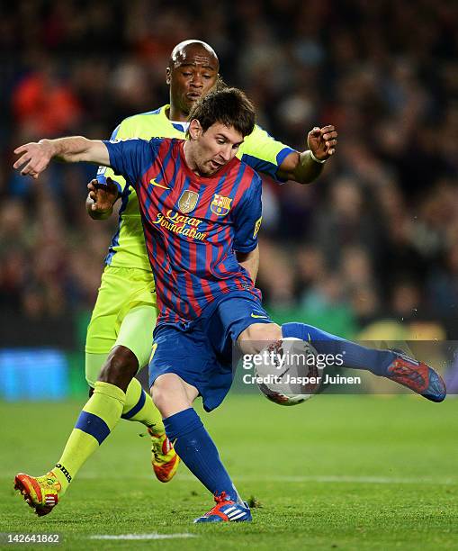 Lionel Messi of FC Barcelona shoots on goal while he duels with Tshepo Masilela of Getafe during the La Liga match between FC Barcelona and Getafe CF...