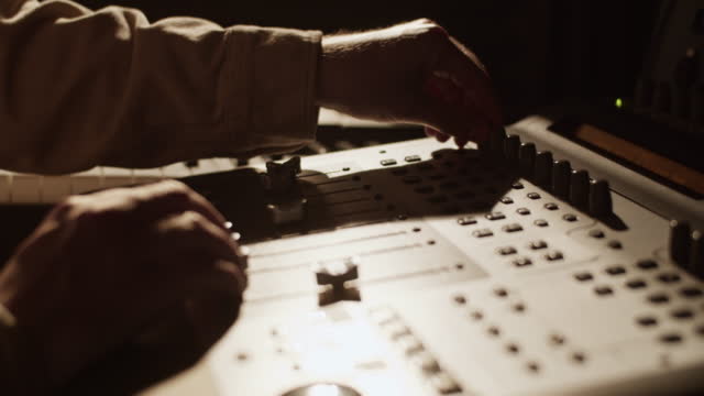Producer using mixing console in studio