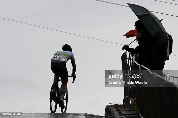Silhouette of Dylan George of Australia competing as fans cheer in the rain during the 95th UCI Road World Championships 2022 - Men U23 Road Race a...