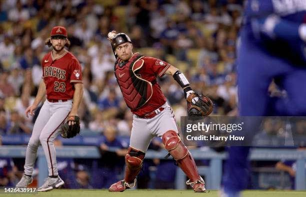 Carson Kelly of the Arizona Diamondbacks throws out Max Muncy of the Los Angeles Dodgers in front of Zac Gallen during the seventh inning at Dodger...