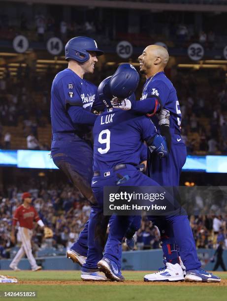 Mookie Betts of the Los Angeles Dodgers celebrates his walk off single with Freddie Freeman and Gavin Lux, for a 3-2 win over the Arizona...